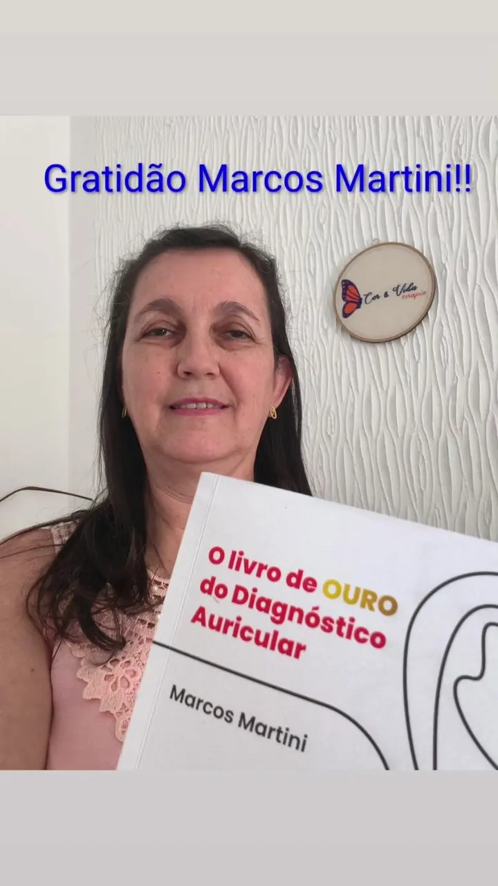Estudante com o Livro de Ouro do Diagnóstico Auricular